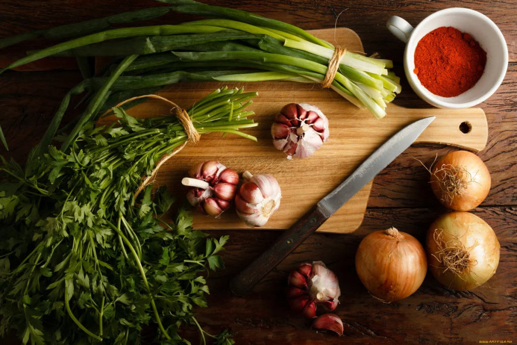 a wooden table topped with lots of fresh vegetables
